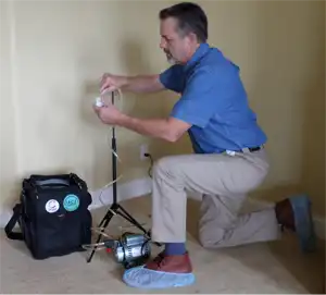 Mold inspector setting up an air pump to test for mold